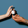 Two hands passing Populum's new high potency 2000mg CBD Tincture