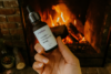 Populum's Lavender Plus CBD Face Oil in front of a cozy fire, because the moisture from this product locks into dry skin
